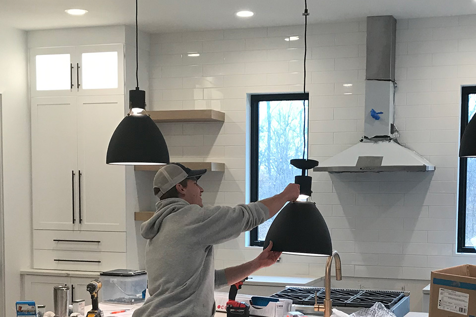 Pals Electric electrician working on residential lighting fixtures in a home