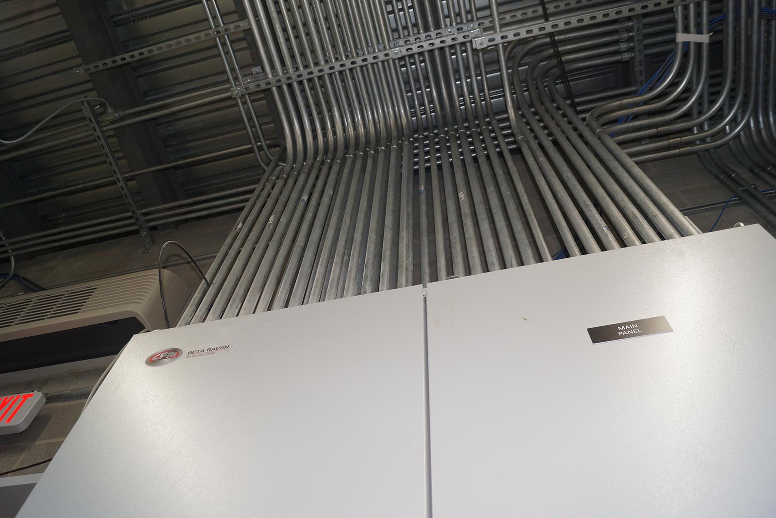 view of electrical panels and conduit from floor to ceiling